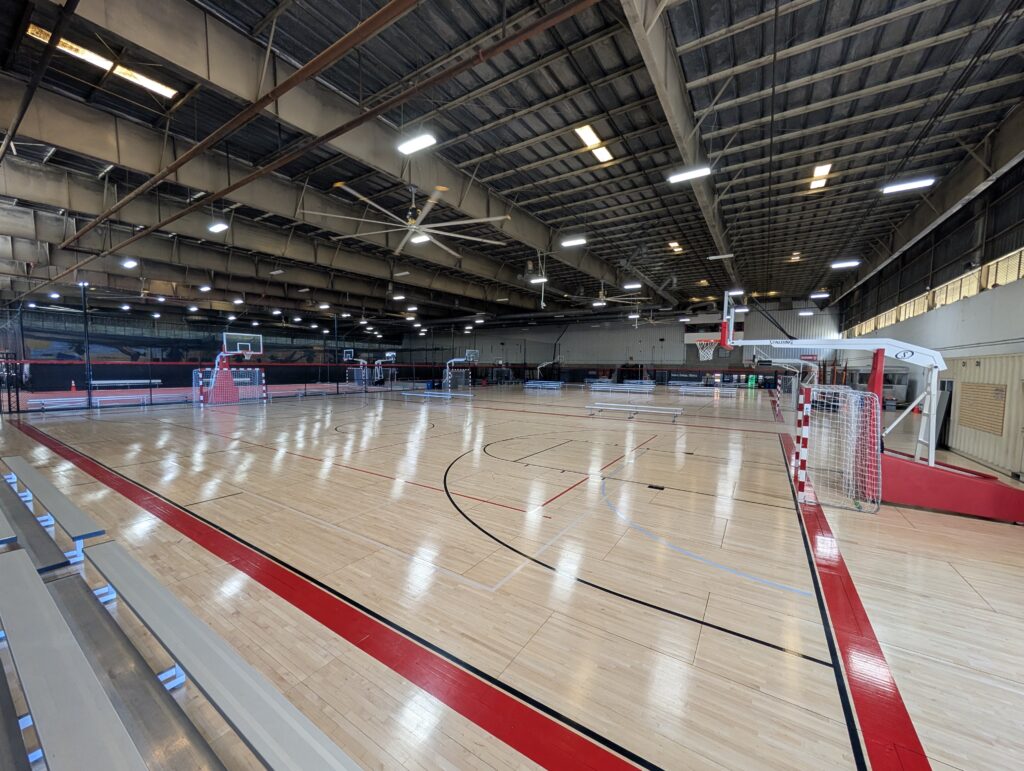 Three wood courts with bleachers along the sideline